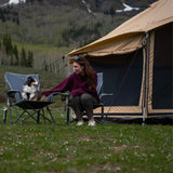 altimus bell tent placed outdoors with a woman enjoying time with her dog in front of the tent